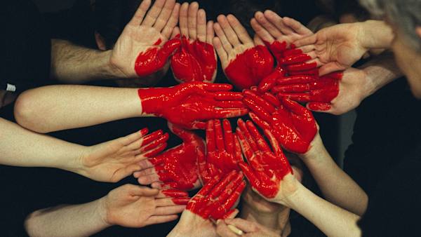 Hands held together painted with a red heart